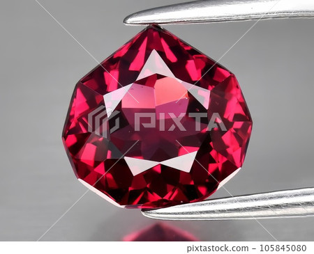 Natural gemstone red rhodolite garnet on gray background Natural gemstone red rhodolite garnet on gray background 105845080
