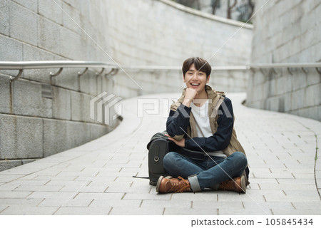 Young male college student traveling with a backpack in Korea Young male college student traveling with a backpack in Korea 105845434