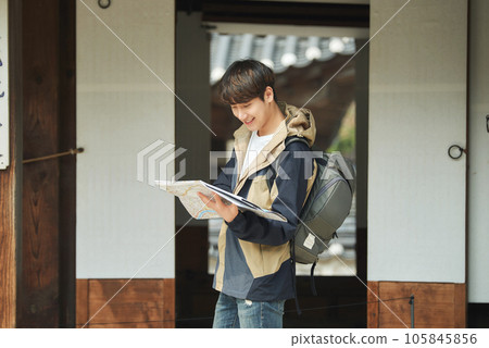 A young male college student who travels with a backpack looking at a map in Korea 105845856