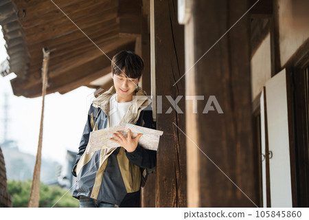 A young male college student who travels with a backpack looking at a map in Korea 105845860