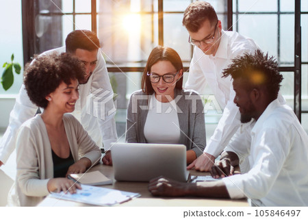 Employees working at computer together, discussing content Employees working at computer together, discussing content 105846497