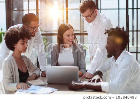 Employees working at computer together, discussing content Employees working at computer together, discussing content 105846498