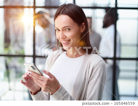 Businesswoman with phone in modern office 105846559
