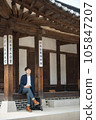 A young man sitting on the stairs looking at his smartphone 105847207