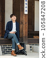 A young man sitting on the stairs looking at his smartphone 105847208