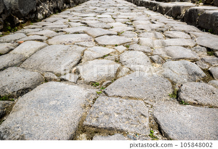 Ancient cobbled road in Pompeii, Italy. Gray granite cobblestones texture 105848002