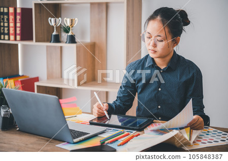 Graphic designer architects who work with laptops and color comparison tables for design work.. 105848387