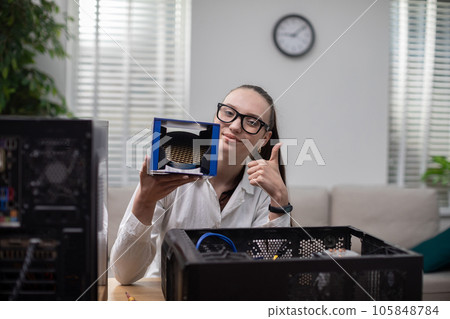 A girl working in an office repairs a computer. A girl working in an office repairs a computer. 105848784