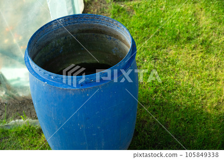 A large plastic barrel standing on the grass A large plastic barrel standing on the grass 105849338