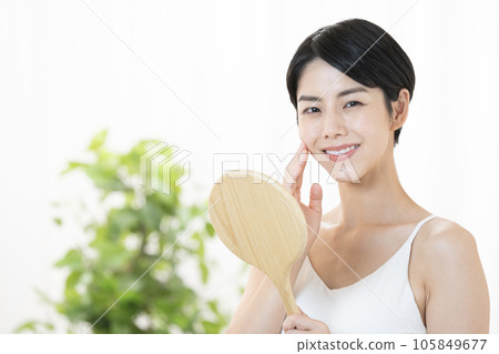 A woman smiling with a hand mirror A woman smiling with a hand mirror 105849677
