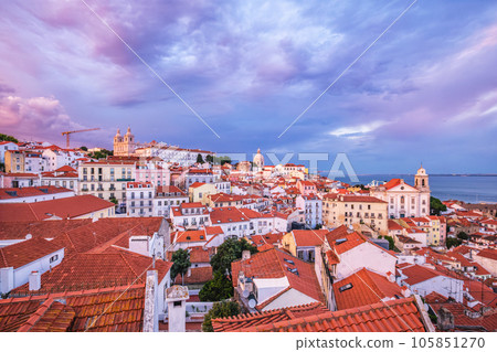 View of Lisbon famous view from Miradouro de Santa Luzia tourist viewpoint over Alfama old city district on sunset with dramatic overcast sky. Lisbon, Portugal. 105851270