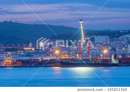 View of Lisbon port with moored sea container ship with port cranes in the evening twilight over Tagus river. Lisbon, Portugal View of Lisbon port with moored sea container ship with port cranes in the evening twilight over Tagus river. Lisbon, Portugal 105851308