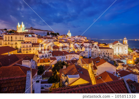 View of Lisbon famous view from Miradouro de Santa Luzia tourist viewpoint over Alfama old city district at night. Lisbon, Portugal. 105851310