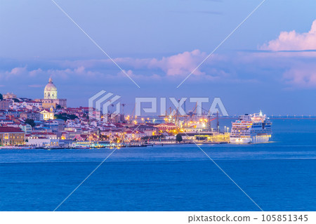 View of Lisbon over Tagus river with moored cruise liner in evening twilight. Lisbon, Portugal View of Lisbon over Tagus river with moored cruise liner in evening twilight. Lisbon, Portugal 105851345