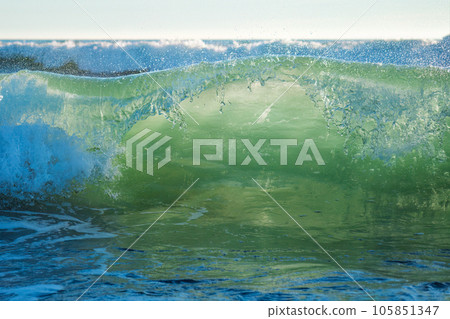 Breaking ocean wave on sunset backlit with sun. Fonte da Telha, Costa da Caparica, Portugal Breaking ocean wave on sunset backlit with sun. Fonte da Telha, Costa da Caparica, Portugal 105851347