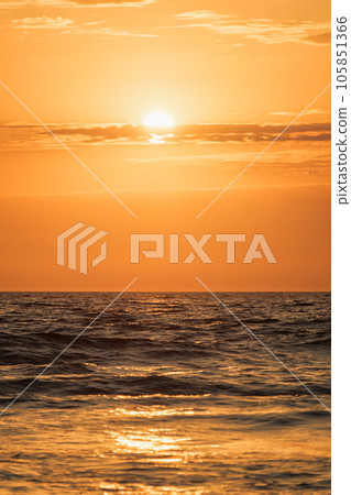 Ocean waves on sunset with setting sun background Ocean waves on sunset with setting sun background 105851366