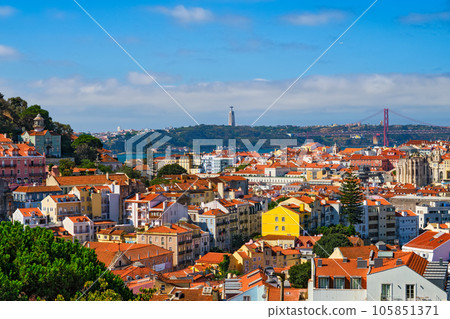 Lisbon famous view from Miradouro dos Barros tourist viewpoint over Alfama old city district, 25th of April Bridge and Christ the King statue. Lisbon, Portugal. 105851371