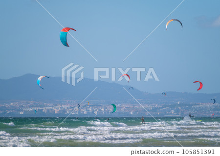 Kiteboarding kitesurfing kiteboarder kitesurfer kites on the Atlantic ocean beach at Fonte da Telha beach, Costa da Caparica, Portugal 105851391