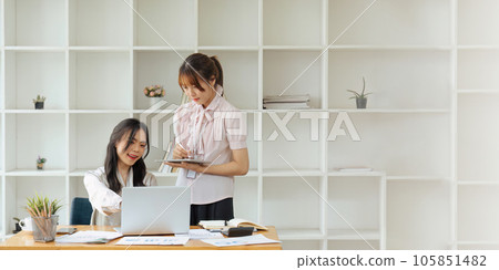 businesspeople working together in office and planning new project looking at laptop and discussing new project in office. 105851482