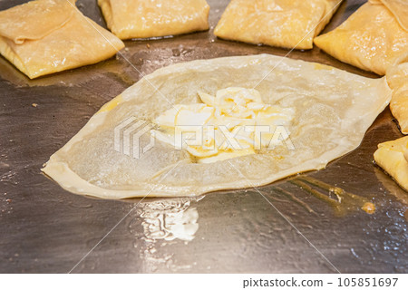 The process of making crepes crispy roti on a frying pan in a restaurant 105851697
