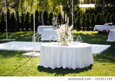Wedding. Banquet. The chairs and round table for guests, served with cutlery. 105851784