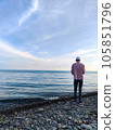 A young man in a panama hat stands on the seashore 105851796