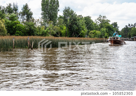 Boat tour on the Parana Delta, Tigre, Buenos Aires, Argentina. Palm trees, construction site of modern brick house. Boat tour on the Parana Delta, Tigre, Buenos Aires, Argentina. Palm trees, construction site of modern brick house. 105852303