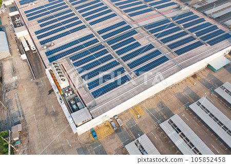 Aerial view of solar panels or solar cells on the roof of factory building rooftop. Power plant, renewable clean energy source. Eco technology for electric power in industry. 105852458
