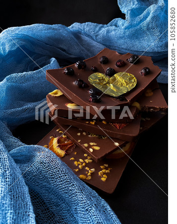 Pieces of chocolate with golden foil heart. With berries, strawberries, oranges Pieces of chocolate with golden foil heart. With berries, strawberries, oranges 105852680