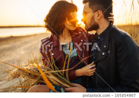 Enjoying time together. Stylish and loving couple enjoying each other by the sea. 105854907