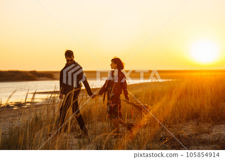 Enjoying time together. Stylish and loving couple enjoying each other by the sea. Enjoying time together. Stylish and loving couple enjoying each other by the sea. 105854914