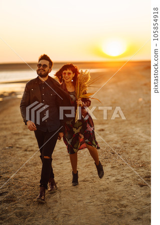 Enjoying time together. Stylish and loving couple enjoying each other by the sea. Enjoying time together. Stylish and loving couple enjoying each other by the sea. 105854918