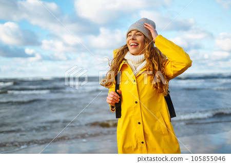 Happy tourist in a yellow jacket enjoying sea landscape at sunset. Travelling, lifestyle, adventure. Happy tourist in a yellow jacket enjoying sea landscape at sunset. Travelling, lifestyle, adventure. 105855046