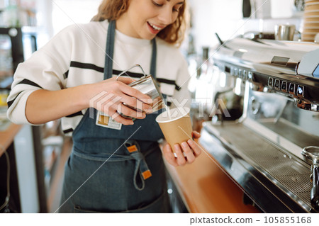 Female barista making coffee in a coffee machine. Conception of business and service. Takeaway food. Female barista making coffee in a coffee machine. Conception of business and service. Takeaway food. 105855168