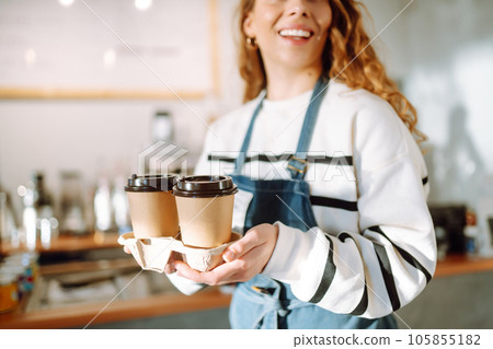 Take-away coffee. Barista girl holding take away coffee at the cafe shop. Takeaway food. 105855182