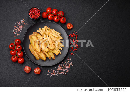 Delicious crispy french fries with salt and spices on a textured concrete background 105855321