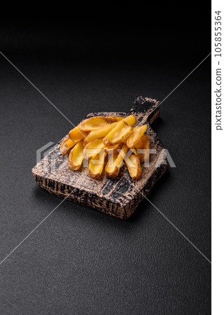Delicious crispy potato deeps with salt and spices on a textured concrete background 105855364
