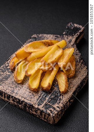 Delicious crispy potato deeps with salt and spices on a textured concrete background 105855367