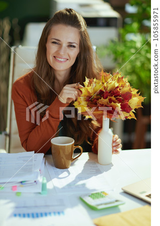 smiling business owner woman in green office 105855971