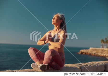 Strong slender lady resting by the waterfront 105856048