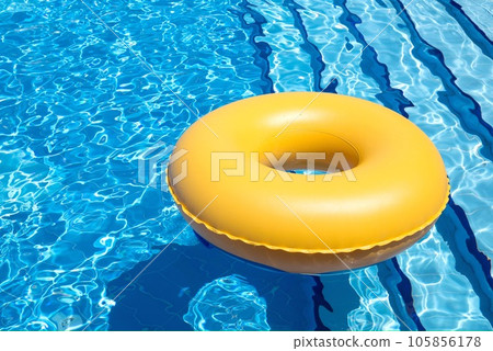inflatable yellow tube floating in clear blue waters inflatable yellow tube floating in clear blue waters 105856178