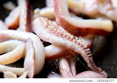 A close-up of a cooking scene in which squid (boiled squid) is fried in a frying pan. A close-up of a cooking scene in which squid (boiled squid) is fried in a frying pan. 105856377