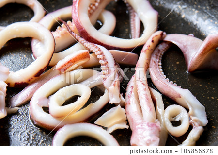 A cooking scene where squid (boiled squid) is fried in a frying pan. A cooking scene where squid (boiled squid) is fried in a frying pan. 105856378