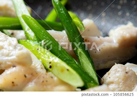 A close-up of a cooking scene in which chicken cartilage (yagen cartilage) and garlic sprouts are fried in a frying pan. 105856625
