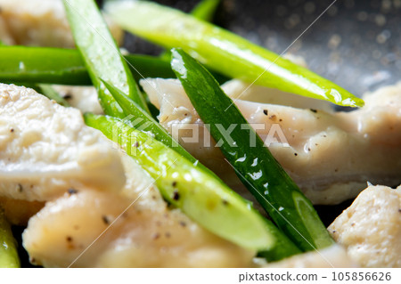 A close-up of a cooking scene in which chicken cartilage (yagen cartilage) and garlic sprouts are fried in a frying pan. 105856626