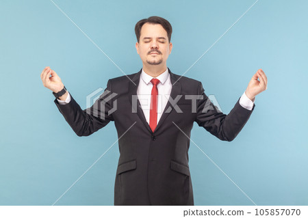 Portrait of relaxed man with mustache standing feels peaceful, practicing yoga, relaxing, wearing black suit with red tie. Indoor studio shot isolated on light blue background. Portrait of relaxed man with mustache standing feels peaceful, practicing yoga, relaxing, wearing black suit with red tie. Indoor studio shot isolated on light blue background. 105857070