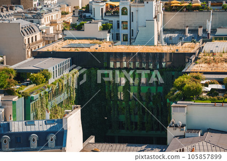 Aerial view of a large corporate office building with a green, triangular roof in a city setting. Aerial view of a large corporate office building with a green, triangular roof in a city setting. 105857899