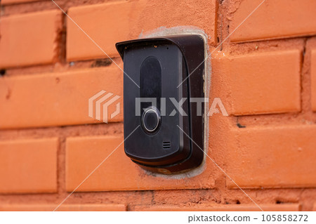 black intercom device on a brick wall 105858272