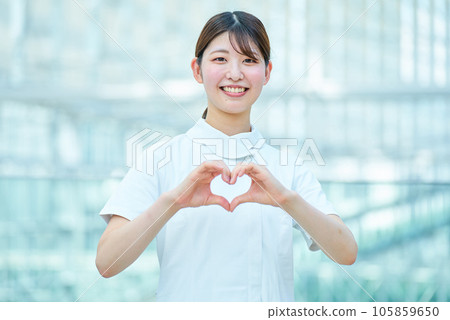 A woman in a white coat making a heart shape with both hands A woman in a white coat making a heart shape with both hands 105859650
