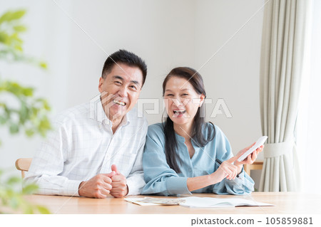 Senior couple turning on household account book Senior couple turning on household account book 105859881